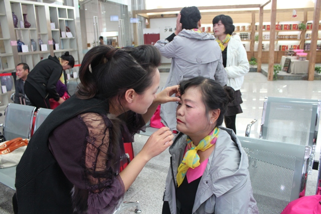 活動開始前,教育廣播女主播幫參與活動演出的老人化妝 活動開始前,教育廣播女主播幫參與活動演出的老人化妝