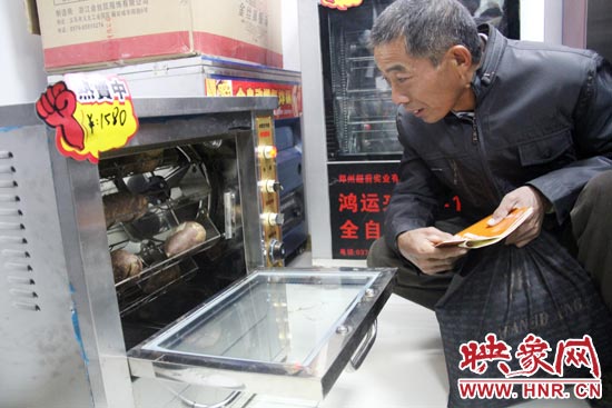 一名科技會(huì)員在看一臺(tái)自動(dòng)化烤紅薯機(jī)器 一名科技會(huì)員在看一臺(tái)自動(dòng)化烤紅薯機(jī)器