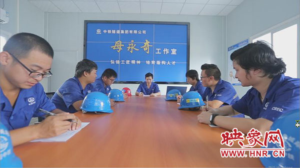 母永奇在以他命名的工作室與同事交流經驗