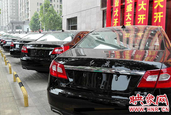 路邊一棟樓上懸掛著二三十條紅色條幅，全部是祝賀一家公司開(kāi)業(yè)的。