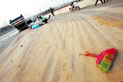 被撞的環衛工躺在地上,身上蓋著藍色布塊,現場除散落的汽車碎片外,還留有被撞斷的掃帚。 被撞的環衛工躺在地上,身上蓋著藍色布塊,現場除散落的汽車碎片外,還留有被撞斷的掃帚。