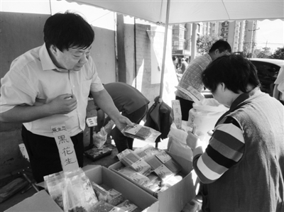 昨日，河南企業(yè)家劉春喜在京“練攤”，為顧客挑選綠豆。新京報記者 張玉學 攝