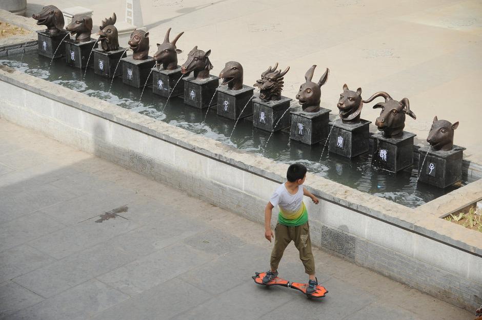 圖為一名市民從獸首旁經過。