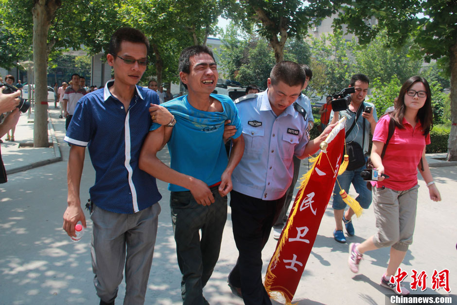 圖為獲救嬰兒父親情緒一度失控，當(dāng)?shù)鼐焦ぷ魅藛T對其進(jìn)行攙扶。張一辰 攝