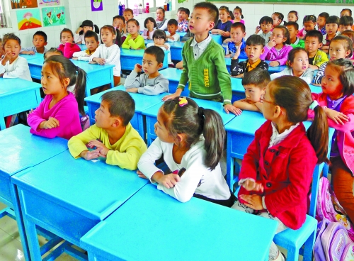 4個小學生擠在3張課桌上 4個小學生擠在3張課桌上