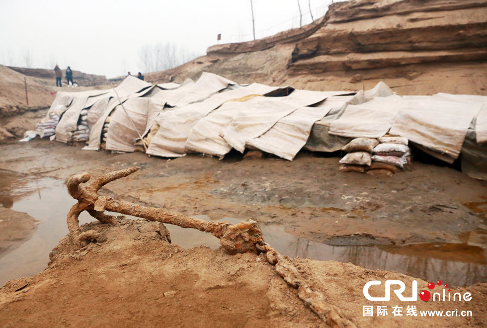 2014年1月6日，河南洛陽古沉船發(fā)掘現(xiàn)場，古沉船鐵錨從見天日，靜靜地躺在古船旁。