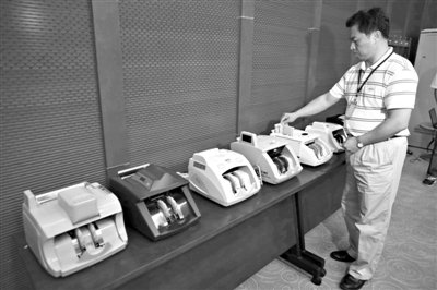 昨日，央行工作人員用各種驗(yàn)鈔機(jī)對C1F9假幣進(jìn)行測試，機(jī)器均能及時作出異常報警反應(yīng)。新京報記者 浦