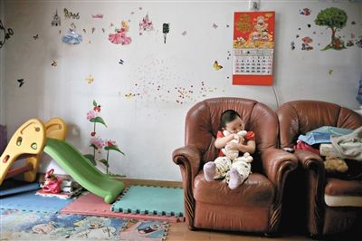 6月14日，未婚媽媽于軍的家里。女兒悅悅抱著兔子玩偶，在聽媽媽手機上的兒歌，這個4歲女孩喜歡兔子。