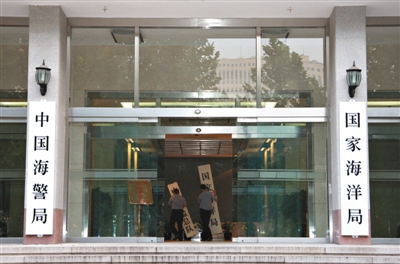 昨日，中國(guó)海警局掛牌成立。原國(guó)家海洋局和中國(guó)海監(jiān)總隊(duì)的牌匾被摘下，國(guó)家海洋局和中國(guó)海警局的新牌匾換上。黃冉 攝