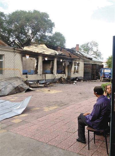 7月27日，海倫聯(lián)合敬老院內(nèi)，幾名老人看著對(duì)面被燒毀的特護(hù)病房。新京報(bào)記者 涂重航 攝