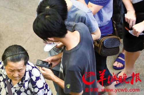 排隊的“黃?！备魇謭桃化B白紙，上面寫好了要掛號的人的信息，包括姓名、電話、要掛的科室等。穿黑白花紋衣服的老婆婆正在排隊掛號