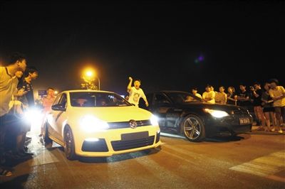 8月24日晚，東壩中街飆車現(xiàn)場(chǎng)，兩輛車并排等待出發(fā)指令，旁邊許多愛(ài)好者前來(lái)觀看比賽。新京報(bào)記者