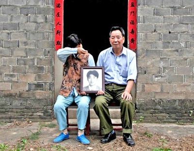 江蘇鎮(zhèn)江，老劉夫婦捧著獨(dú)生子的遺像在老家前留影南方都市報(bào)供圖L