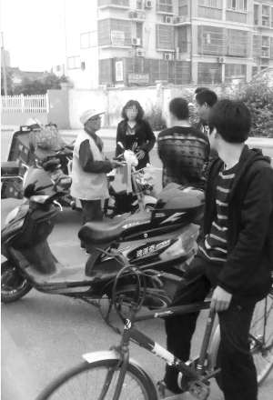 穿環衛工作服的是顧大爺,旁邊的女子是車主