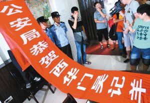 面對警方收繳的條幅,老板楊某也不好意思地用手遮擋臉 面對警方收繳的條幅,老板楊某也不好意思地用手遮擋臉