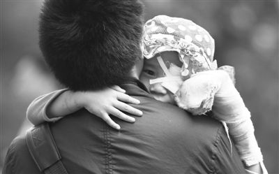 昨日，北京同仁醫院，被砍傷的彤彤趴在舅舅的肩上。他們剛剛掛完號，正準備回旅館。新京報記者 尹亞飛 攝