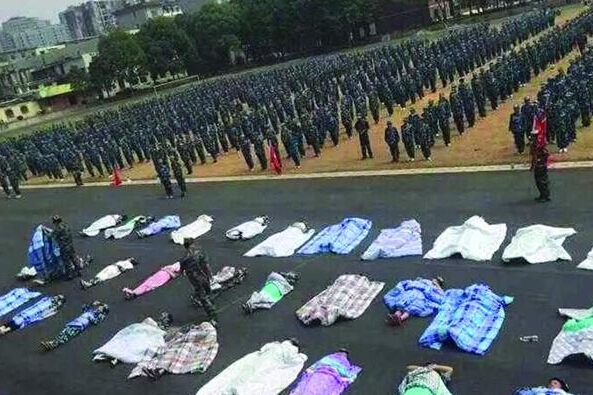 20多名女生躺在瀝青跑道上,身上嚴嚴實實地裹著棉被,接受太陽的照曬。 20多名女生躺在瀝青跑道上,身上嚴嚴實實地裹著棉被,接受太陽的照曬。