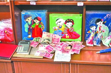 　　2012年6月21日，在朝鮮羅先特別市的一家商店里，柜臺上散落著一些人民幣。在朝鮮，人民幣比本國