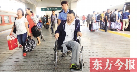 李剛手術后歸來，在車站工作人員幫助下走出鄭州火車站站臺  東方今報首席記者 張曉冬 攝