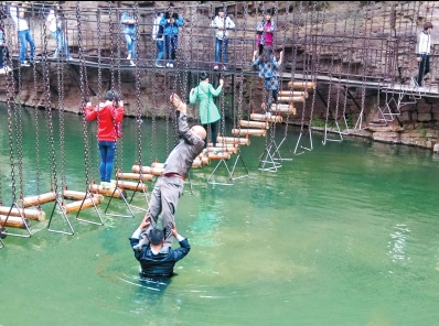 中年男游客正踩著景區(qū)安全員郭小明的肩膀過河。網(wǎng)友“@我的小名叫張孩”供圖