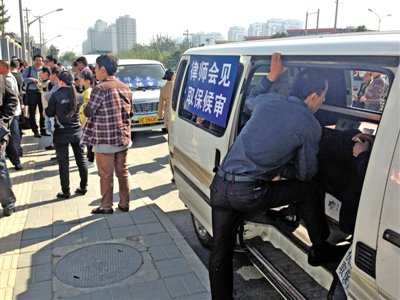 昨日，朝陽區看守所門前有人排隊。大門外還停有多輛寫有“律師會見”字樣的車。