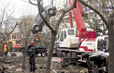 輸油管道爆炸后，搶修人員將被炸毀的車輛運出現場。