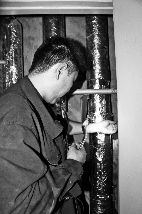 苗師傅一邊進行維修，一邊用耳機接聽市民的電話。