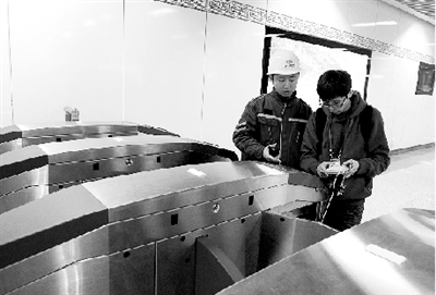 昨天上午，體育中心站，工作人員正在對進出站閘機進行調試。