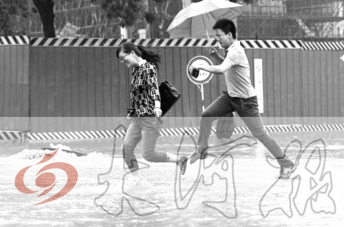 鄭州經三路與北環交叉口處，積水較深，行人們不得不“練輕功”。 記者 白周峰 攝影