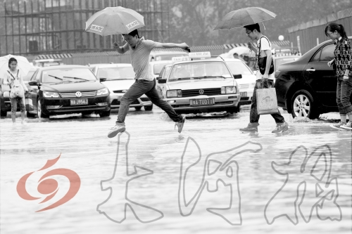 鄭州經三路與北環交叉口處，積水較深，行人們不得不“練輕功”。 記者 白周峰 攝影