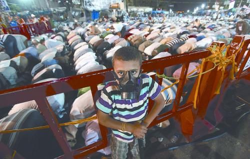 當(dāng)?shù)貢r(shí)間28日晚，在埃及開羅納賽爾城，一名小男孩頭戴防毒面具參加穆兄會(huì)的集會(huì)示威。