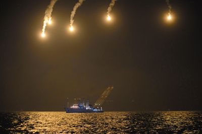 22日,搜救人員在照明彈的光亮下連夜搜救。 22日,搜救人員在照明彈的光亮下連夜搜救。