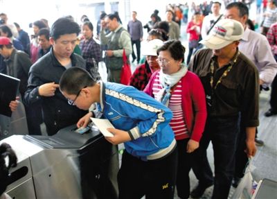 去年5月5日，14號線園博園站，乘客刷卡出地鐵。北京公交地鐵將實行計程票制，多乘坐多付費。