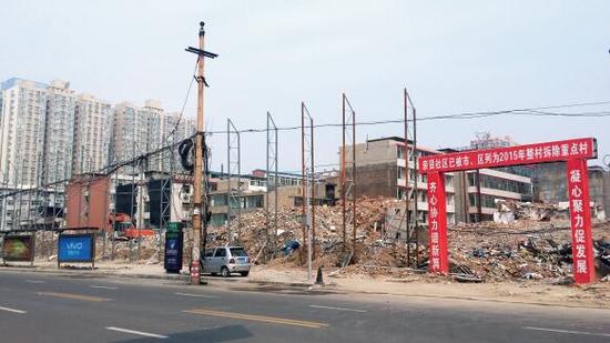 015年5月31日，在社區干部的帶頭拆遷下，親賢社區的“城中村改造”拉開帷幕。由于前期“清產核資”及補償標準等因素，拆遷改造工作推進并不順利。圖為位于體育西路東側集體所有的商鋪率先被拆遷完畢，用于遮擋的圍擋正在施工中。（拍攝：2015年9月16日）