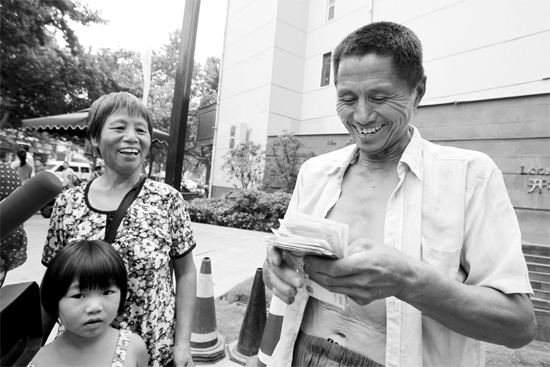 昨日，鄭州市明達路與豐慶路交叉口西300米路南，來自中牟的瓜農拿到西瓜款，笑開顏東方今報記者袁曉強