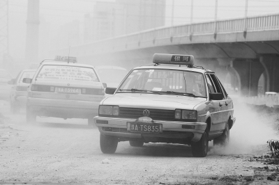 施工的道路上，車輛通過塵土飛揚。
