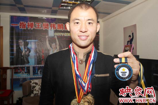 樊偉鵬向大家展示自己剛獲得的吉尼斯獎牌。 樊偉鵬向大家展示自己剛獲得的吉尼斯獎牌。