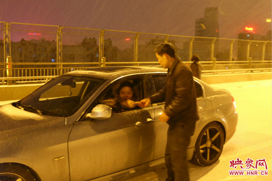 “推車人”幫助一輛車上坡后，收取“勞務費”。