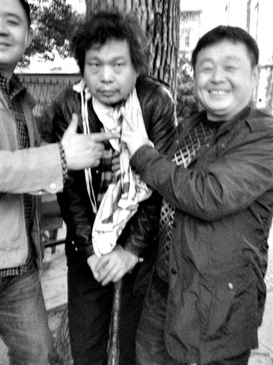 兩名接訪人員與患有癌癥的訪民段新德合影時(shí),面帶笑容擺出勝利的手勢(shì)。 兩名接訪人員與患有癌癥的訪民段新德合影時(shí),面帶笑容擺出勝利的手勢(shì)。