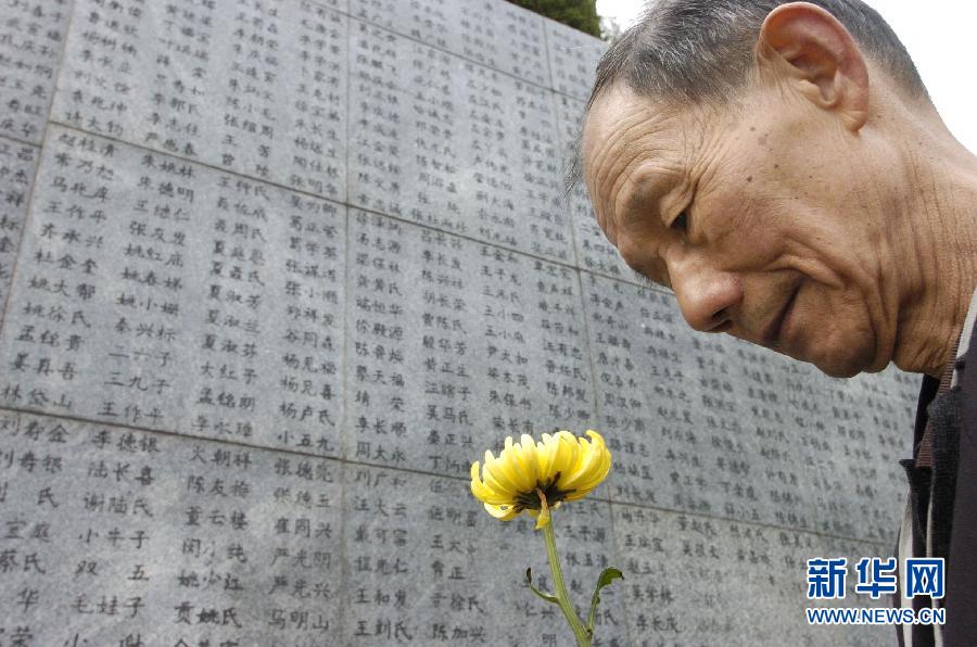 2006年4月5日，74歲的南京大屠殺幸存者佘子清手捧鮮花，祭奠被日軍殺害的母親。
