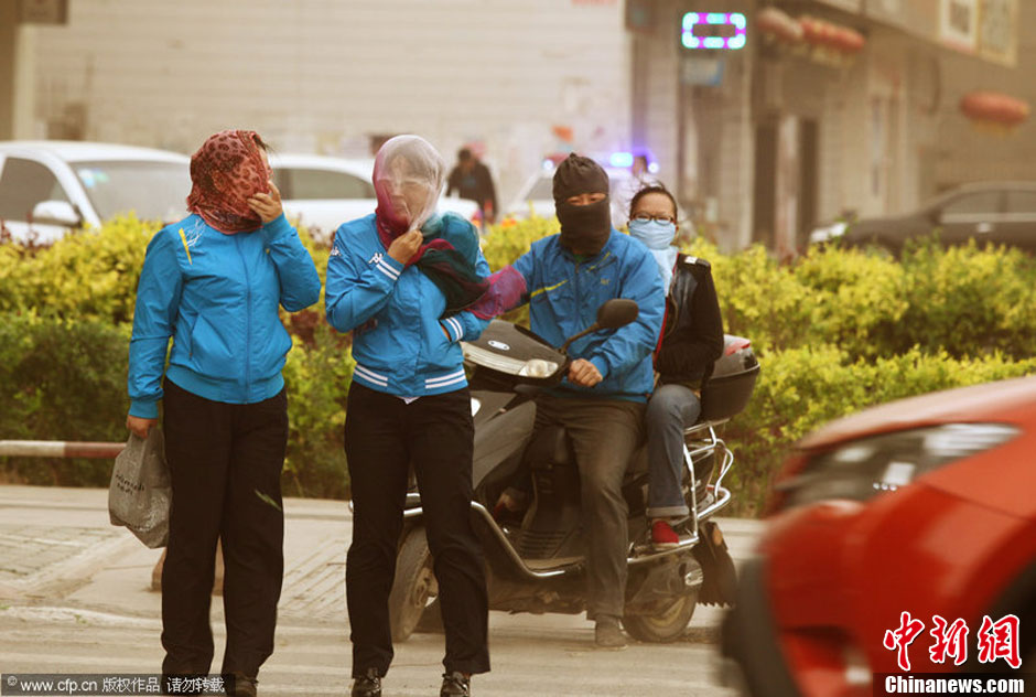 2014年04月23日,新疆維吾爾自治區吐魯番地區,市民戴著口罩行走在大風沙塵中的吐魯番市街頭。 2014年04月23日,新疆維吾爾自治區吐魯番地區,市民戴著口罩行走在大風沙塵中的吐魯番市街頭。