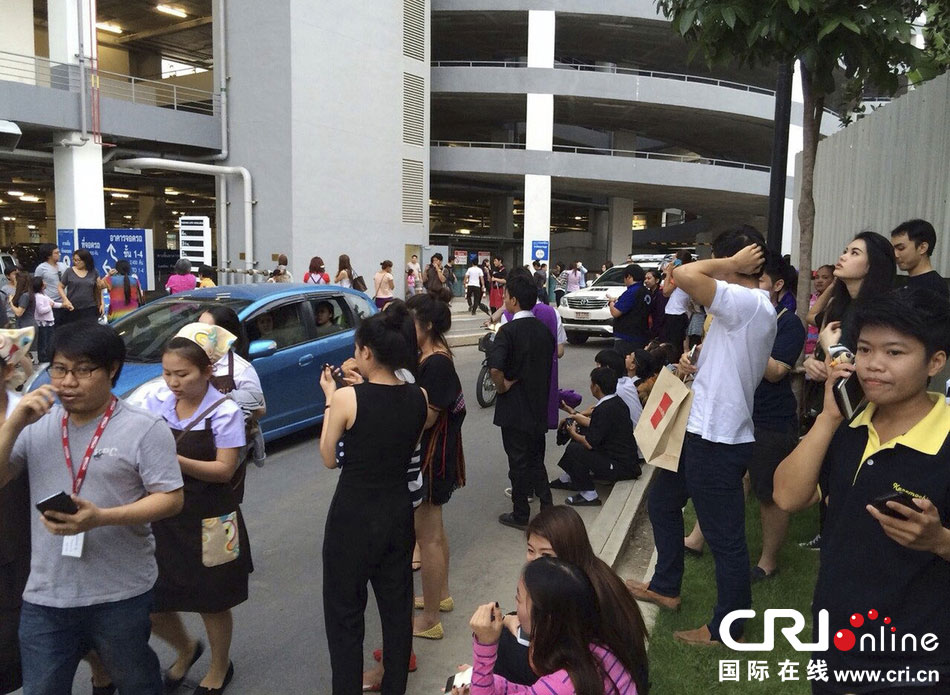 當地時間2014年5月5日,泰國清萊,工人們站在一棟大樓外避難。 當地時間2014年5月5日,泰國清萊,工人們站在一棟大樓外避難。