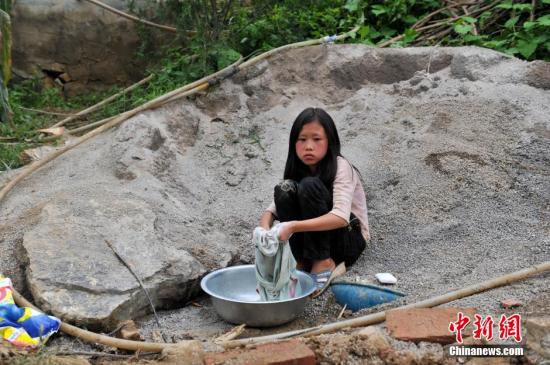 8月9日，云南巧家紅石巖村，10歲的劉鑫蕊在洗自己的衣服