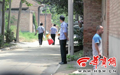 昨日,西安市閻良區譚家村,警方在事發的孫某家里勘查現場后,將提取的物證帶走 華商報記者 黃利健 攝