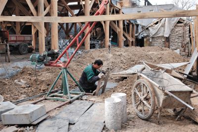 東城區北鑼鼓巷與小經廠胡同之間一處四合院內，工人進入已經挖好的地下室內施工。