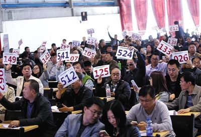 競拍者正在練習舉牌動作,以便拍賣時讓工作人員看清號牌。 競拍者正在練習舉牌動作,以便拍賣時讓工作人員看清號牌。