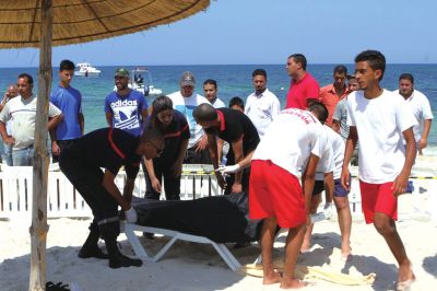 6月26日,在突尼斯蘇塞,救生員和醫務人員在發生襲擊事件的海灘運送一名死者的遺體。新華社發 6月26日,在突尼斯蘇塞,救生員和醫務人員在發生襲擊事件的海灘運送一名死者的遺體。新華社發