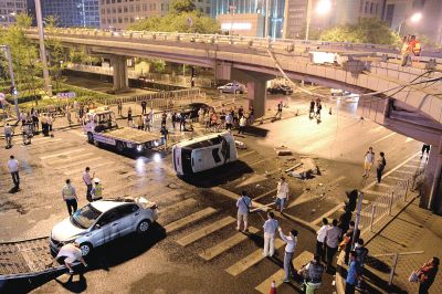 路虎沖下國貿橋砸中一輛起亞轎車，橋上厚達幾十厘米的水泥護欄被撞斷，碎石四處散落，數十群眾在現場圍觀。