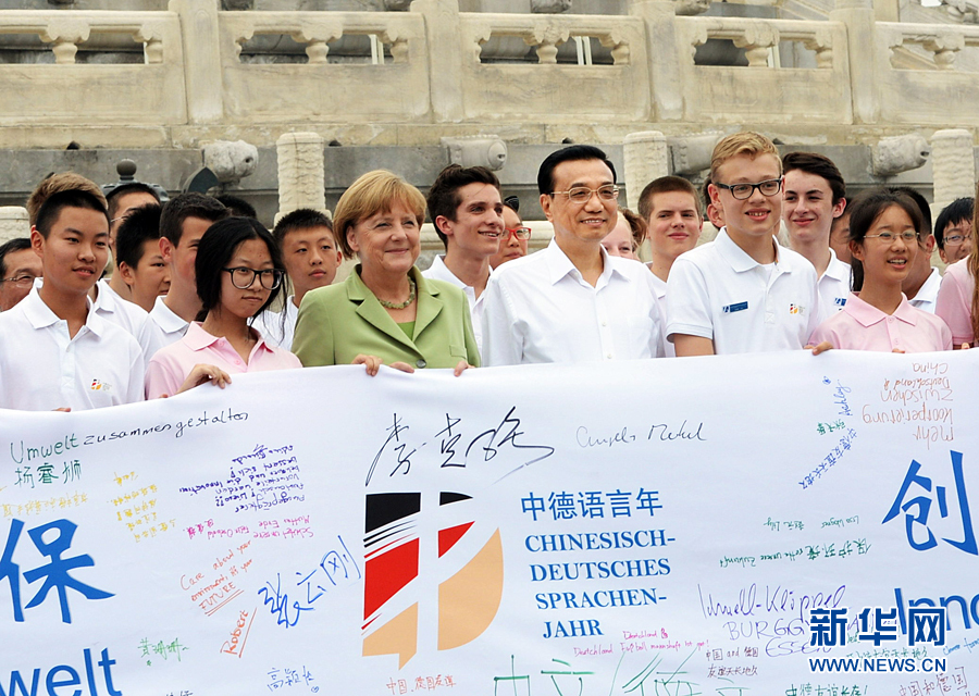 李克強同默克爾與青少年在天壇祈年殿前合影留念。 李克強同默克爾與青少年在天壇祈年殿前合影留念。