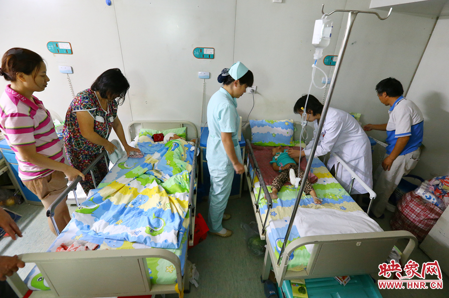 手術(shù)前，畫面右側(cè)的大龍正在接受醫(yī)生的檢查，左側(cè)的小龍還在熟睡。